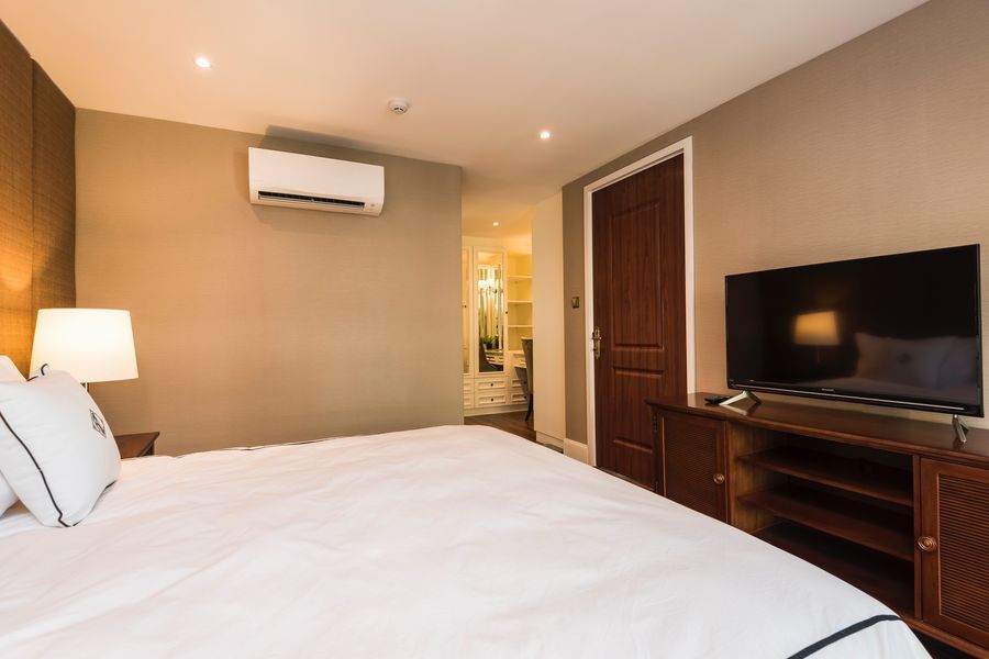 A bedroom with a television and the walk in closet beyond