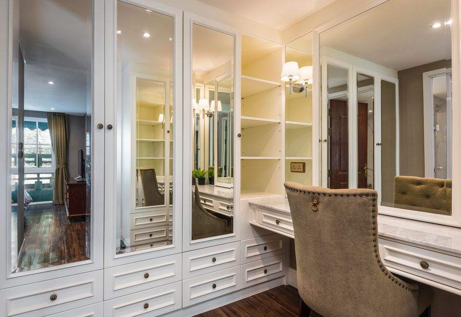 The mirrored walk in closet with hanging space and drawers