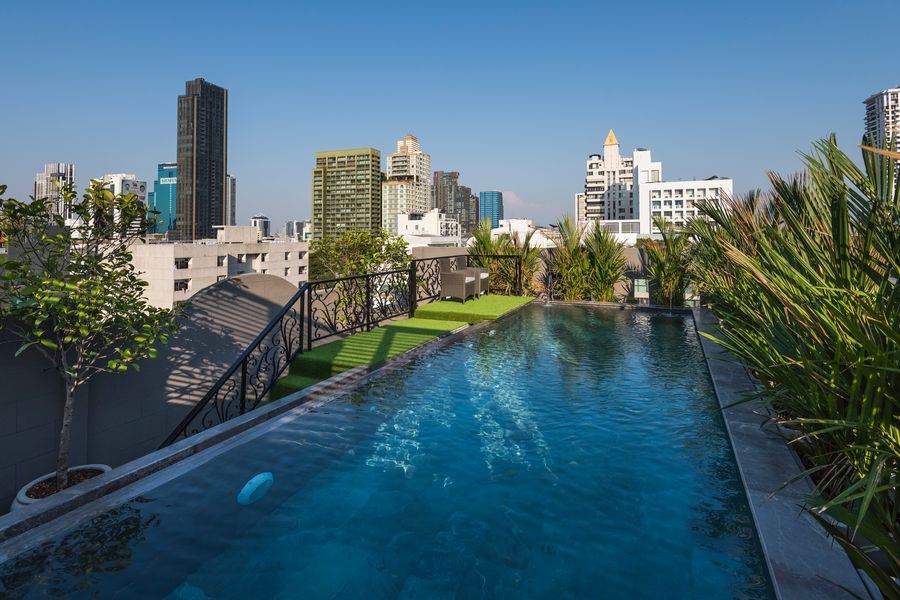 The rooftop pool and wrought iron balustrade at The Elite Thong Lor 25