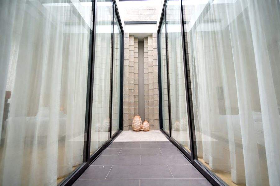 The glass light well at the centre of the upper floor at The Elite @ Pattaya, with sheer curtains either side