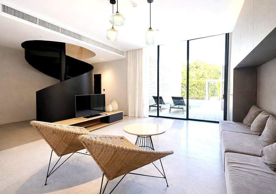 The open living and dining room at The Elite @ Pattaya seen from the kitchen, with the spiral stair to the two bedrooms above