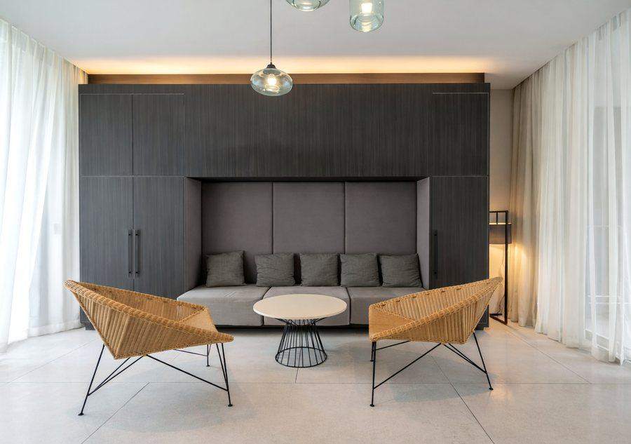 A built in sofa between dark wardrobes at The Elite @ Pattaya, under a glass pendant light