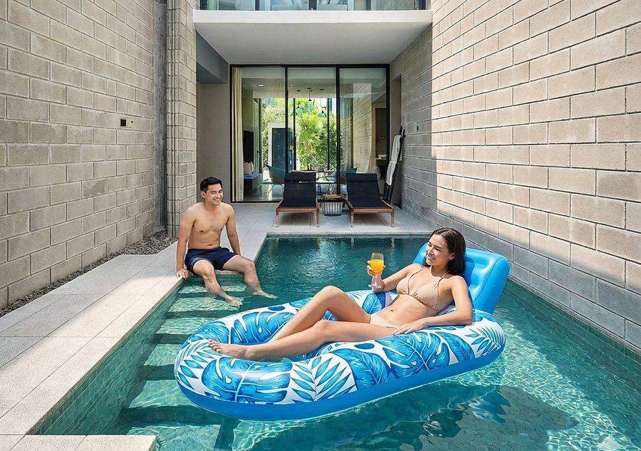 The private pool at The Elite @ Pattaya, a two storey villa at Bang Sare, with guests on a float and loungers on the terrace