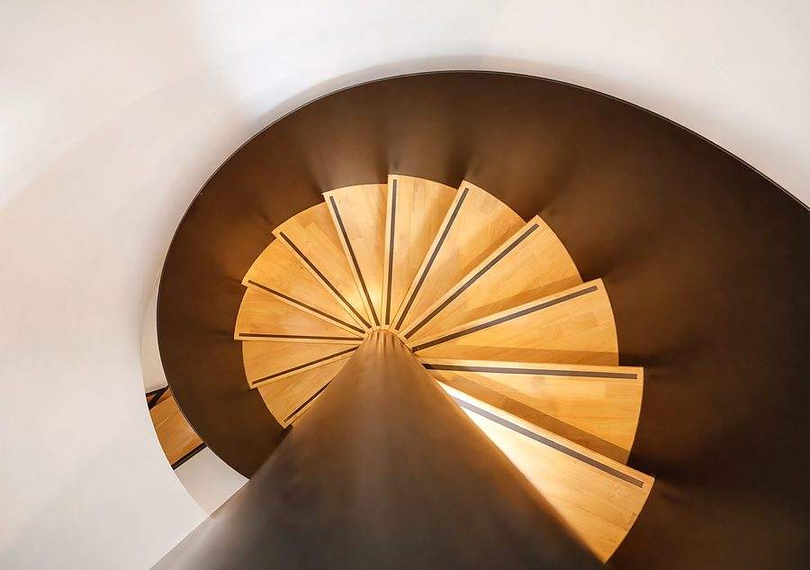 The spiral staircase at The Elite @ Pattaya photographed from directly above, the oak treads fanning out